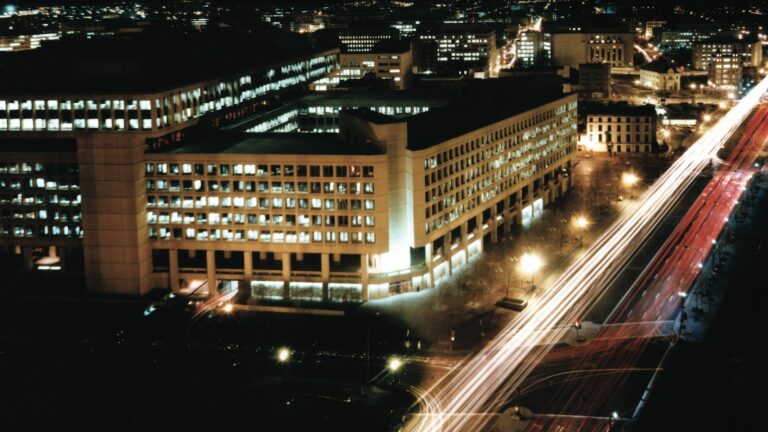 J. Edgar Hoover Building (FBI HQ) at night — Arctic Frost / DOJ-FBI dragnet motif